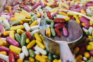 El çok renkli jöle fasulye toplama bir kepçe ile