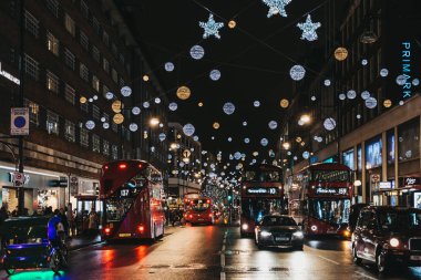 Çift katlı kırmızı otobüs, siyah kabinler ve Oxford Street, Londra, araçlarda Noel ışıkları ile dekore edilmiştir..