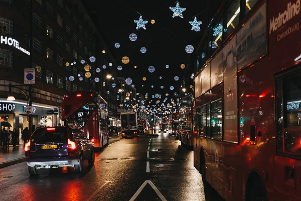 Çift katlı kırmızı otobüs, siyah kabinler ve Oxford Street, Londra, araçlarda Noel ışıkları ile dekore edilmiştir..