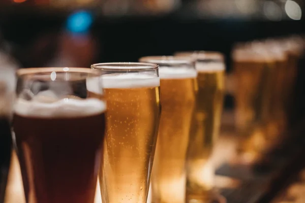 Close Rack Diferentes Tipos Cervejas Escuro Luz Uma Mesa Foco — Fotografia de Stock