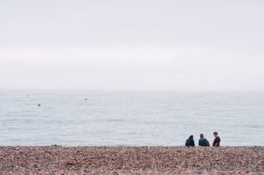 Brighton, İngiltere - 17 Ekim 2017: West Pier Brighton, İngiltere'de en popüler sahil Hedef Yurtdışı turistler için bakarak sahilde oturan insanlar. 