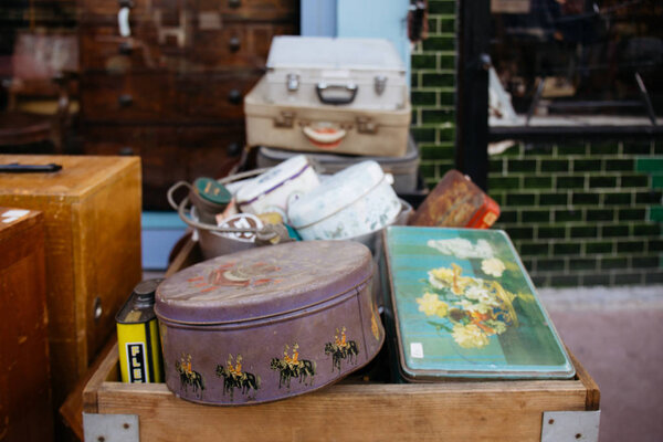 LONDON, UK - MARCH 21, 2016: Stack of vintage suitcases and various vintage items in Chatsworth Road Market. The market has a long heritage and is located on one of London's longest high streets.