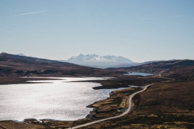 Loch Leathan ve yaşlı adam Storr trek, Isle of Skye, İskoçya, karlı dağın yoldan görünümünü arka planda.