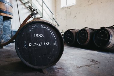 BRORA, SCOTLAND - MARCH 22, 2018: Barrels of Clynelish whiskey inside Brora Distillery, Scotland. The distillery closed in 1983 and is currently being refurbished to reopen in 2020. clipart