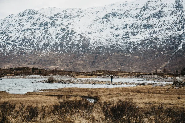 男子步行由 Scowcapped 山和湖在苏格兰高地 苏格兰 在春季 — 图库照片