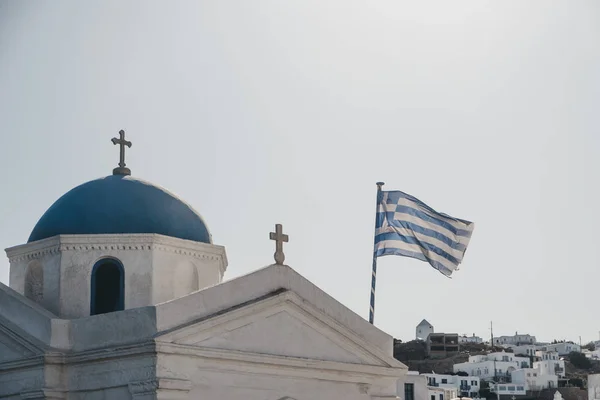 Drapeau grec dans le vent sur l'église orthodoxe de Mykonos, Grèce — Photo
