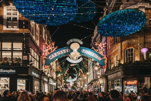 Mennesker som går under Prosjekt Null - bærekraft tematisert Christma – stockfoto