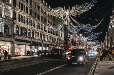 Londra 'daki Regent Caddesi' nde Noel ışıkları altında siyah bir taksi.,