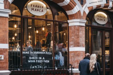Cov 'daki Franco Manca restoranının önünden geçen insanlar.