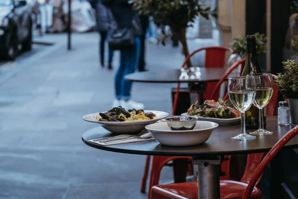 Comida y vino en la mesa al aire libre de un restaurante, selectivo fo — Foto de Stock