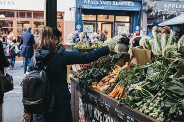 Borough 'daki Ted Sebze Dükkanı' ndan taze sebze alan kadın.