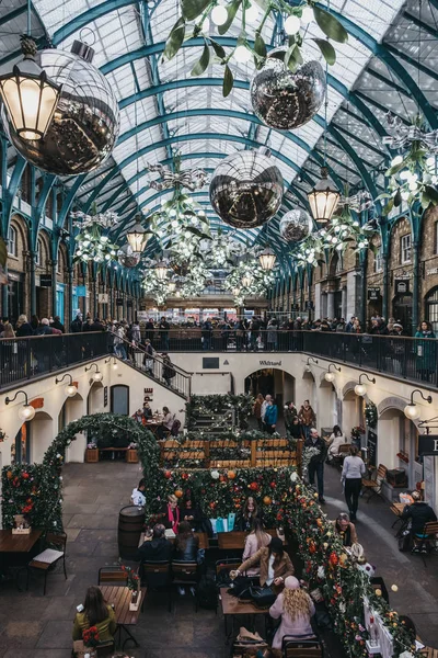 Ludzie siedzący przy stołach na świeżym powietrzu kawiarni w Covent Garden Mark — Zdjęcie stockowe