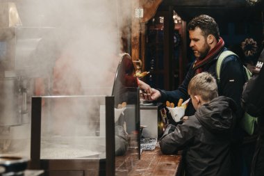 İnsanlar Trafa 'daki Noel pazarından churro alıyor.