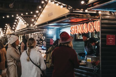 İnsanlar Southbank Center W 'daki Biftek ve Chips standından yemek sipariş ediyor.