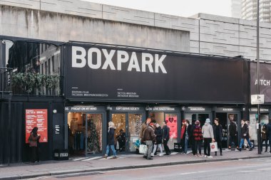 People walking past the shops at BOXPARK mall in Shoreditch, Lon clipart