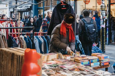 Brick Lane, Londra, Uk 'taki bir markette kitap okuyan bir kadın.
