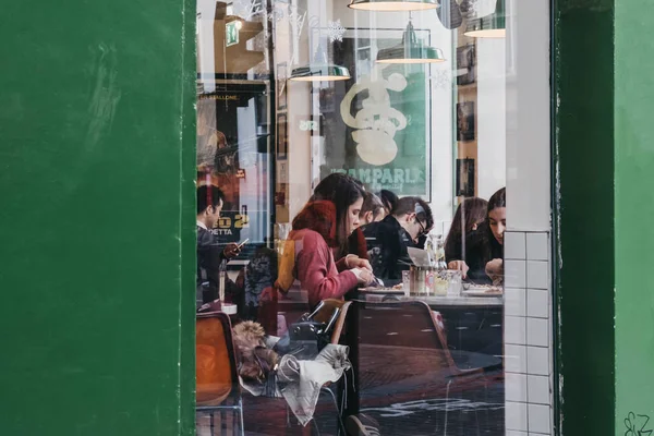 Vista através da janela de pessoas dentro de um restaurante em Shoredi — Fotografia de Stock