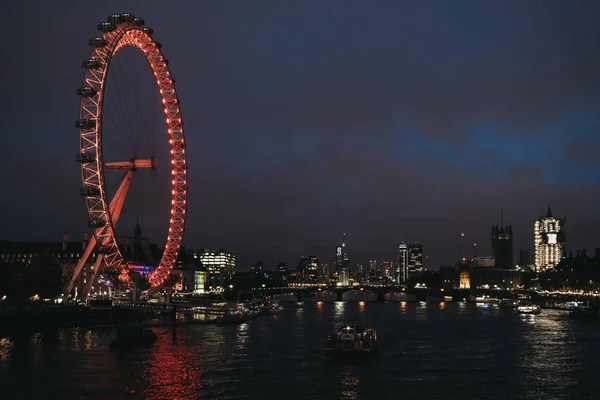 Londons Auge und die Skyline der Stadt von der Millennium Bridge bei Nacht, Großbritannien. — Stockfoto