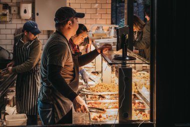 Londra, Uk - 26 Kasım 2019: Camden Market 'teki bir gıda standındaki personel Londra' nın en yoğun perakende satış noktalarından biridir. Seçici odak.