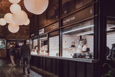 Londra, Uk - 26 Kasım 2019: insanlar Camden Market, Londra 'da sıra sıra yiyecek tezgahları kuruyorlar. 1974 'te 16 tezgahla başlayan Camden Market, Londra' nın en işlek perakende satış merkezlerinden biri..