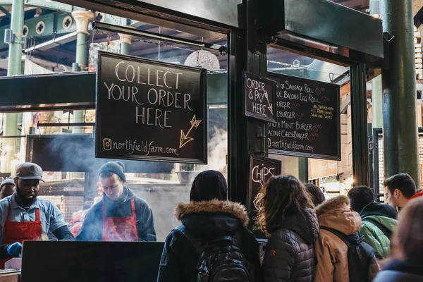 ロンドン 11月29 2019 ノースフィールド バッチリーで食べ物を待っている人々は ボーフ市場に立っており 背景にスタッフが料理をしています バラ市場は ロンドン最大の市場の一つ 英国です — ストック写真