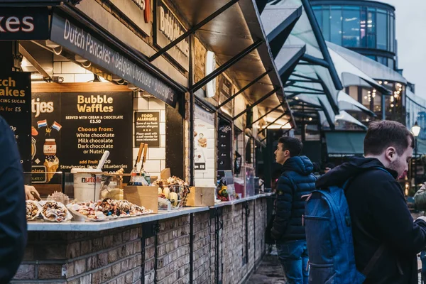 ロンドン イギリス 2019年11月26日 ロンドンのカムデンマーケットにある屋台の列 人々が歩く 選択的な焦点 1974年に16の屋台で始まり カムデン市場はロンドンで最も忙しい小売スポットの1つです — ストック写真