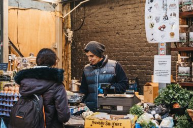 Londra, Uk - 29 Kasım 2019: Londra 'nın en büyük ve en eski gıda pazarlarından biri olan Borough Market' teki bir markette satıcı ve müşteri.