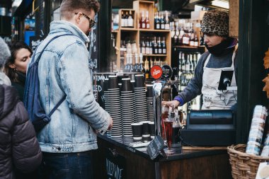 Londra, Uk - 29 Kasım 2019: Londra 'daki en büyük ve en eski gıda pazarlarından biri olan Borough Market' ten içki sipariş eden adam.
