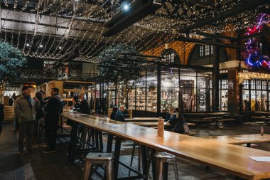 London, UK - November 29, 2019: Interior of Spitalfields Market, one of the finest Victorian Markets in London with stalls offering fashion, antiques and food, people inside, selective focus.