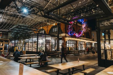 London, UK - November 29, 2019: Interior of Spitalfields Market, one of the finest Victorian Markets in London with stalls offering fashion, antiques and food, people inside, motion, selective focus.