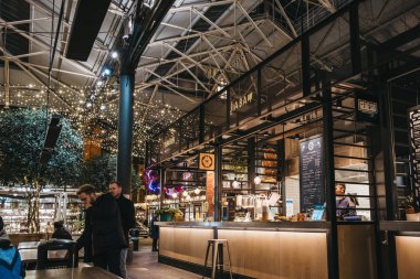 London, UK - November 29, 2019: Street food stalls inside Spitalfields Market, one of the finest Victorian Market Halls in London with stalls offering fashion, antiques and food. Selective focus.