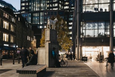 London, UK - November 29, 2019: I Goat sculpture by Kenny Hunter in Spitalfields, London, UK, in the evening, people walking by, motion blur. The statue was inspired by social history of Spitalfields.