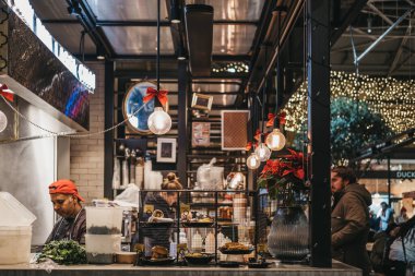 Londra, Uk - 14 Aralık 2019: Londra 'nın en iyi Viktorya dönemi marketlerinden biri olan Spitalfields Market' teki Hint gıda tezgahında moda, antika ve yiyecek sunan ürünler. Seçici odak.