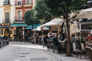 Seville, İspanya - 17 Ocak 2020: Seville 'deki bir restoranın açık masalarında, Güney İspanya' nın Endülüs bölgesinin başkenti ve popüler bir turizm merkezi.