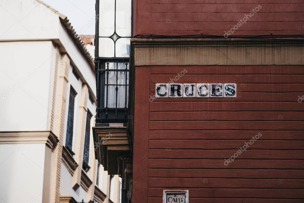 Street name sign on Cruces street in Seville, Andalusia, Spain.