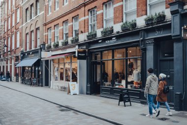 Londra, İngiltere - Mart 06, 2020: Covent Garden 'daki dükkanlar sırası, Londra' da çok sayıda dükkan ve restoranı olan popüler bir turizm alanı, çok az insan önünden geçiyor, hareket bulanıklığı.