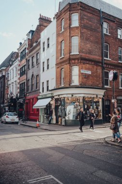 Londra, İngiltere - Mart 06, 2020: Londra 'nın LGBTQ + barları, restoranları ve kulüpleriyle ünlü Soho' daki mağazalar ve kafeler, insanlar önde yürüyor, hareket bulanıklığı.