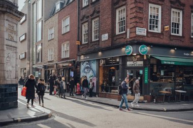 Londra, İngiltere - Mart 06, 2020: Londra 'nın LGBTQ + barları, restoranları ve kulüpleri ile ünlü olan Soho' daki kafe ve restoranlar, oradan geçen insanlar, hareket bulanıklığı.