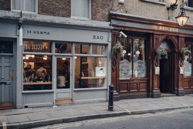 Londra, İngiltere - Mart 06, 2020: Londra 'nın LGBTQ + barları, restoranları ve kulüpleriyle ünlü bir bölgesi olan Soho' daki Bao restoranının cepheleri ve John Snow barı.