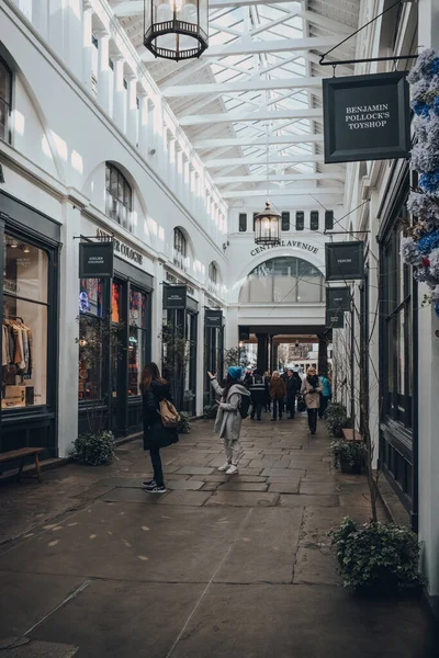 Londra, İngiltere - 06 Mart 2020: Londra, İngiltere 'deki en popüler turizm merkezlerinden biri olan Covent Garden Market' teki dükkanların önünden geçen insanlar.