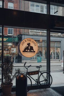 Londra, İngiltere - Mart 06, 2020: Soho, Londra 'daki Joe & The Juice cafe' deki tabelada bisiklet. Joe & The Juice, dünyada 200 'den fazla yerde bulunan bir meyve suyu bar ve kahve dükkânı zinciri..