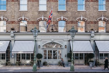 Londra, İngiltere - 6 Mart 2020: Soho 'daki Charlotte Street Hotel' in önünde sigara içen kadın, güneşli bir bahar gününde Londra 'nın barları, restoranları ve kafeleri ile ünlüdür..