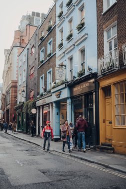 Londra, İngiltere - 06 Mart 2020: Soho 'daki kafeler ve restoranlar sırası, Londra' nın merkezindeki barlar ve lokantalarla ünlü bir alan, yanından geçen insanlar, hareket bulanıklığı.