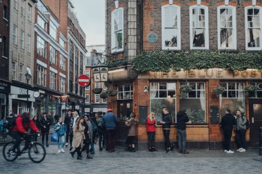 Londra, İngiltere - Mart 06, 2020: Londra 'nın LGBTQ + barları, restoranları ve kulüpleriyle ünlü bir bölgesi olan Soho' daki Blue Posts Bar Cephesi 'nin önünden geçen insanlar, hareket bulanıklığı.