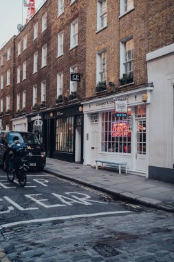Londra, İngiltere - Mart 06, 2020: Soho 'daki Johnnys Parçalama Dükkanı' nın ön cephesi, Londra 'da çok sayıda mağazası ve restoranı, arabası ve bisikletçisi olan ünlü bir turistik bölge, hareket bulanıklığı.