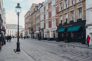 Londra, İngiltere - 06 Mart 2020: Covent Garden, Londra 'da bir caddede dükkanların önünden geçen çok az insan, seçici bir odak noktası. Covent Garden, Londra 'da birçok dükkan ve restoranı olan ünlü bir turizm alanıdır..