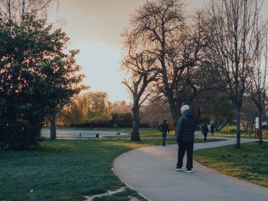 Londra, İngiltere - 28 Mart 2020: İnsanlar sadece egzersiz yapmak ve Coronavirus tehdidinden uzak durmak istedikleri için Londra 'da bir parkta ayrı yürüyorlar.