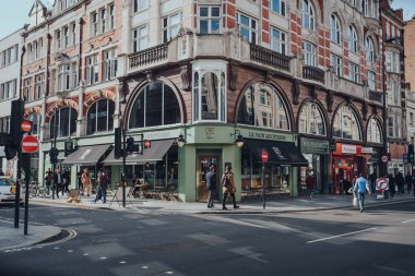 Londra, İngiltere - 06 Mart 2020: Fitzrovia 'daki dükkanların ve restoranların önünden geçen insanlar, Londra' nın çeşitli bölgelerinde restoranlar, oteller, galeriler ve eski okul barları bulunuyor.