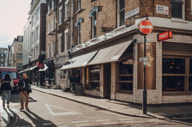 Londra, İngiltere - Mart 06, 2020: Soho 'da bir caddedeki susuz restoran, Londra' nın LGBTQ + barları, restoranları ve kulüpleri ile ünlü bir alan, insanların yanından geçtiği.