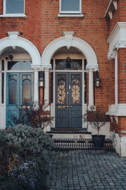 Londra, İngiltere - 22 Mart 2020: Londra, İngiltere 'de geleneksel Viktorya döneminden kalma bir evin lekesiz ahşap kapısı. Viktorya dönemindeki bir evde lekeli camlar odak noktası olmaya devam ediyor..